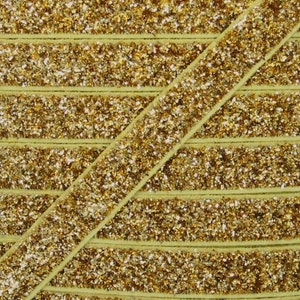 May include: Gold glitter elastic trim with a light green velvet backing. The trim is shown in multiple rows.