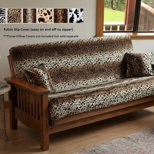 May include: A wooden futon frame featuring a slip cover with a brown and black leopard print pattern. The text on the image reads Futon Slip Cover (easy on and off no zipper) and Throw Pillow Covers not included but sold separate.