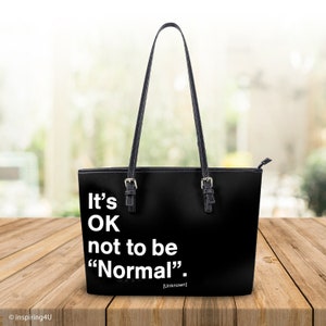 Könnte beinhalten: Schwarze Tragetasche mit weißem Text, der "It's OK not to be "Normal". [Unbekannt]" lautet.