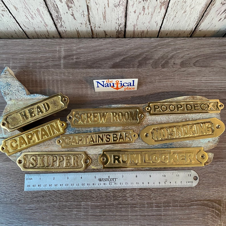 May include: A set of ten brass nautical door signs with various room names, including "Head", "Captain", "Screw Room", "Captain's Bar", "Poop Deck", "No Smoking", "Skipper", and "Rum Locker".