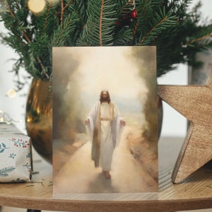 Op de afbeelding: Een schilderij van Jezus Christus die op een pad loopt met zijn armen uitgestrekt. Het schilderij is gemaakt in aquarelstijl met zachte kleuren en een wazige achtergrond.