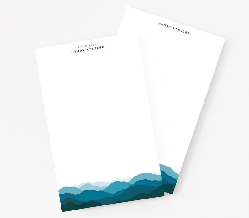 May include: A note pad with a mountain range design in shades of blue. The text "A note from Henry Kessler" is printed at the top of the pad.