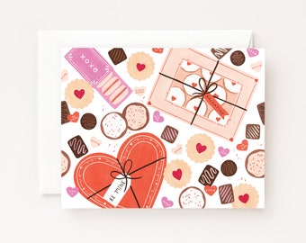 May include: A Valentine's Day card with a pink and white gift box, a heart-shaped box of chocolates, and various cookies and chocolates. The text on the card says "Valentine" and "Be Mine".