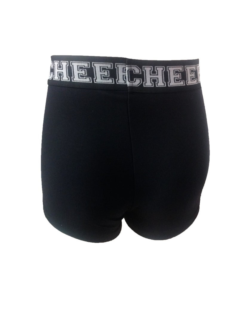 May include: Black athletic shorts with a white band at the waist. The band features the word "CHEECH" in a bold, block letter font. The shorts are made of a smooth, stretchy fabric.