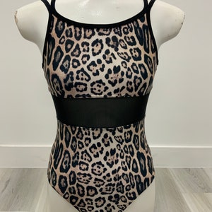 May include: A black and brown leopard print leotard with a black mesh panel across the midsection. The leotard has thin straps.