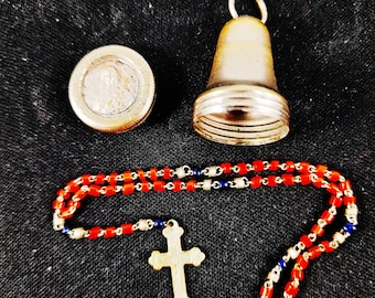 Rosario miniatura antiguo, cuentas de vidrio artístico rojo y azul oscuro, cadena y cruz de alambre de plata, estuche plateado en forma de campana, completo de 5 décadas.