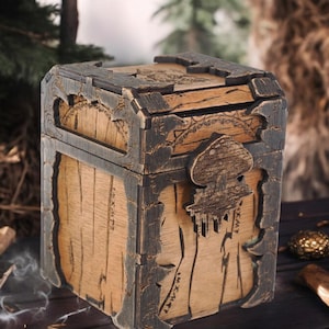 Könnte beinhalten: Eine Holzkiste mit dunkelbrauner Oberfläche und aufwendigen Schnitzereien. Die Kiste hat einen Klappdeckel und einen Metallverschluss in Form eines Schädels. Die Kiste ist mit Runen und Symbolen verziert.