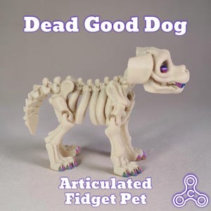 May include: A cream-colored articulated dog skeleton toy with text that reads "Dead Good Dog" and "Articulated Fidget Pet." The dog has purple and blue accents on its eyes and toes. The toy is designed to be a fidget toy.