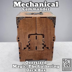 Op de afbeelding: Een bruine houten deckbox met de tekst "Mechanical Commander" en "Oversized Magic: The Gathering Deck Box." De box heeft metalen hoekaccenten en een tandwielvormig ontwerp aan de voorkant.