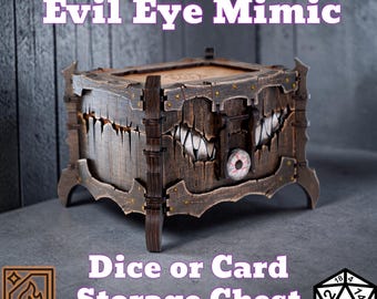May include: A wooden Evil Eye Mimic dice or card storage chest. The chest is brown with a distressed finish, featuring a carved design of a monster's mouth and an eye. The text "Evil Eye Mimic" and "Dice or Card Storage Chest" are visible.
