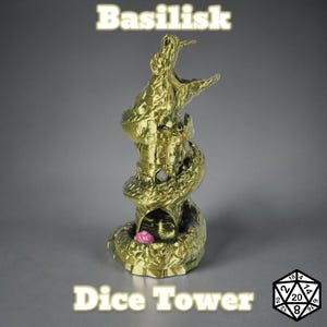 May include: A gold-colored dice tower shaped like a basilisk, with the text "Basilisk Dice Tower" in a glowing font. A pink die is visible inside the tower. A twenty-sided die is in the lower right corner.