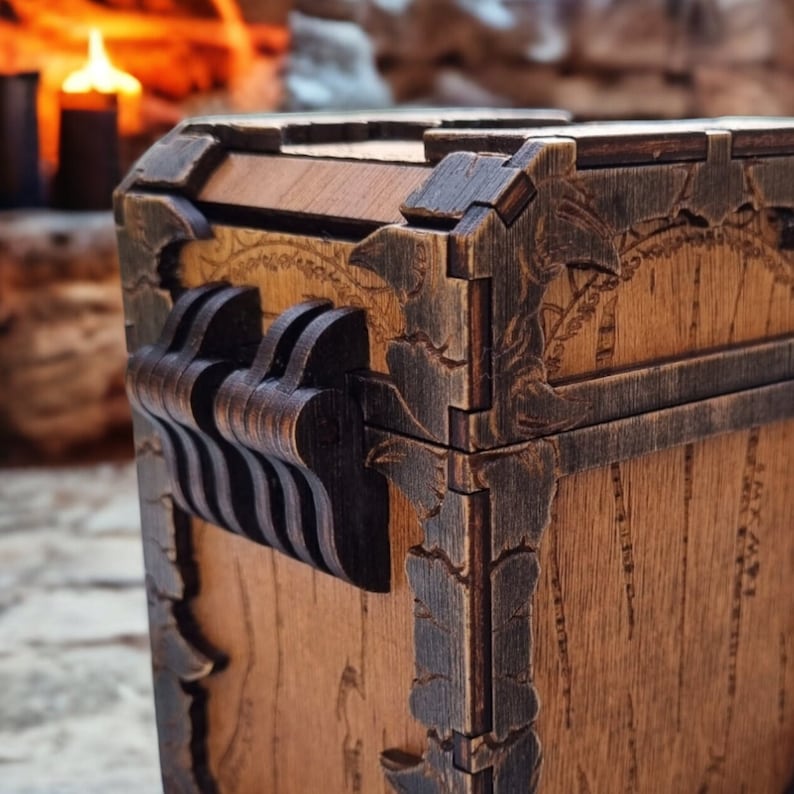 May include: Wooden chest with intricate carved details and metal accents. The chest features a dark brown finish with decorative corner pieces and a unique latch design. The wood grain is visible, adding to the rustic aesthetic. The chest is likely used for storage.