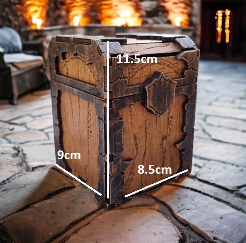 May include: A wooden treasure chest with a distressed finish, measuring 9cm x 8.5cm x 11.5cm. The chest features metal accents and a decorative shield-shaped clasp. The wood has a warm brown tone, and the chest appears to be aged.