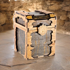 May include: A wooden treasure chest with a detailed design. The chest features a combination of light and dark wood, with intricate carvings and a shield-shaped emblem on the front. The chest has a rustic, aged appearance.