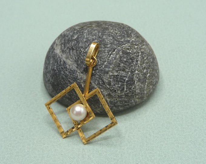 Gold pendant adorned with a white pearl. Vintage.