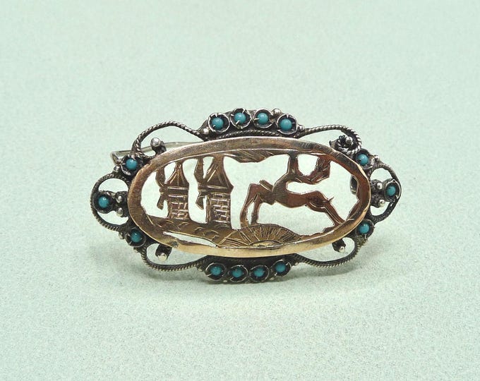 Antique silver brooch adorned with blue stones.