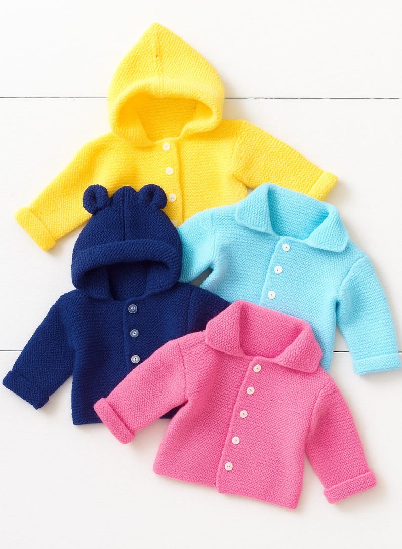 May include: A collection of four knitted cardigans in yellow, navy blue, light blue, and pink. The yellow and navy blue cardigans feature hoods, with the navy blue version including bear ears. The light blue and pink cardigans have collars.