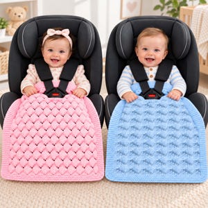 May include: Two infants sit in black car seats, each secured with a five-point harness. One infant wears a pink textured knit blanket, while the other wears a blue textured knit blanket. Both blankets feature a repeating diamond pattern.