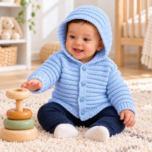 May include: A light blue knitted hooded cardigan featuring a ribbed texture and four small blue buttons down the front. The garment has long sleeves with ribbed cuffs and a matching ribbed hem, providing a consistent look across the entire piece.