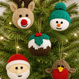 May include: Five round, hand-knitted Christmas baubles featuring a reindeer with a red nose, a snowman in a teal hat, a brown Christmas pudding with holly, a Santa Claus face with a white beard, and a brown robin with a bright red chest.