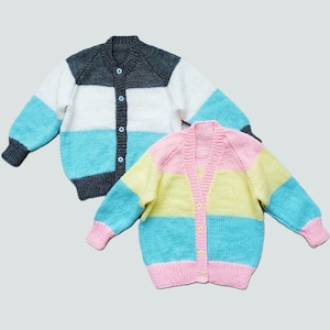 May include: Two striped knitted cardigans with button fastenings. One cardigan is grey, white, and blue. The other cardigan is pink, yellow, and blue.