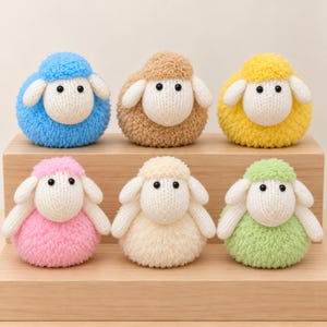 May include: Six round, plush sheep figurines made of textured yarn. Each sheep features a cream-colored face with two black eyes and two floppy ears. The bodies are colored in blue, tan, yellow, pink, off-white, and light green respectively.