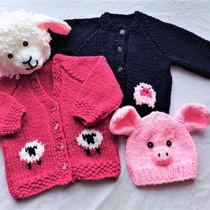 May include: Three knitted baby cardigans in pink, blue, and white with animal appliques. The pink cardigan has two white sheep appliques, the blue cardigan has a pink pig applique, and the white hat has a pink pig face.