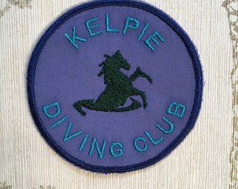 Embroidered cryptid iron on patch: Kelpie Diving Club.