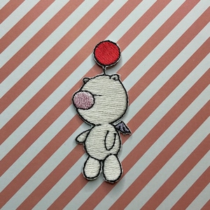 May include: White embroidered plush toy with a pink nose and a red balloon on top. The toy has a small wing on its back.