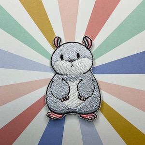 May include: An iron-on patch featuring a cartoon hamster embroidered in grey with pink ears and feet.