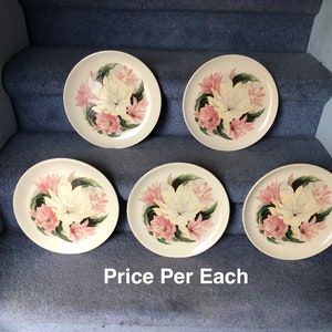May include: Set of five white ceramic dinner plates with a floral design featuring pink and yellow flowers. The text "Price Per Each" is printed on the bottom of the image.