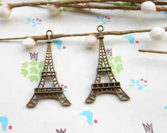 Puede incluir: Dos encantos de la Torre Eiffel en tono dorado antiguo. Los encantos son detallados e intrincados, con un diseño delicado.