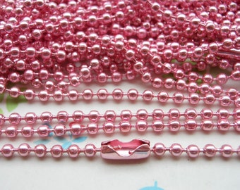 May include: Pink metal chain with round links. The chain is made of small, shiny beads. The chain is approximately 1/4 inch in diameter.