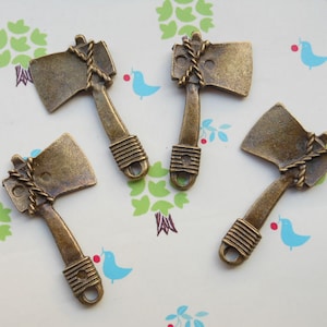 以下が含まれることがあります： ロープのディテールが付いたアンティークブロンズの斧チャーム4個。チャームの長さは約5cmで、ネックレスやブレスレットに取り付けるためのループが上部に付いています。