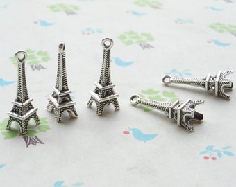 May include: Five silver Eiffel Tower charms, each with a detailed design and a loop for attaching to jewelry or other crafts.