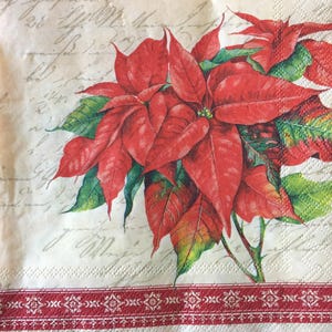 May include: A red poinsettia flower with green leaves on a white background with a red and white border. The background has a vintage look with faded handwriting.