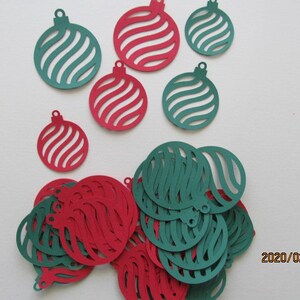 May include: Assortment of red and green paper ornaments with a swirl design. The ornaments are cut out and have a hole at the top for hanging.