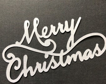 May include: A silver metallic cutout of the phrase "Merry Christmas" on a black background.