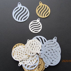 Peut inclure: Une collection d'ornements en papier de couleur blanche, dorée et bleue. Les ornements sont découpés en forme de boule de Noël et présentent un motif en spirale. Les ornements sont disposés sur une surface noire.