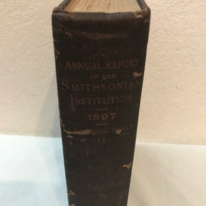 May include: A dark brown leather-bound book with the title "Annual Report of the Smithsonian Institution 1897" on the spine.