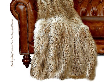 May include: A brown and white faux fur throw blanket draped over a brown leather sofa. The blanket is soft and fluffy, and it would be perfect for adding warmth and comfort to any room.