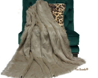 May include: A plush faux fur throw blanket in a light brown colour draped over a dark green velvet armchair with a leopard print cushion. The throw blanket is soft and fluffy, and the armchair is tufted with buttons. The text "Fur Accents®" is visible in the bottom right corner of the image.