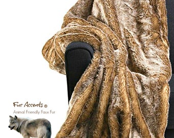 May include: A brown and gray faux fur throw blanket draped over a black armchair. The blanket has a long, shaggy pile and is made from animal-friendly faux fur. The text "Fur Accents® Animal Friendly Faux Fur" is visible in the lower left corner of the image.