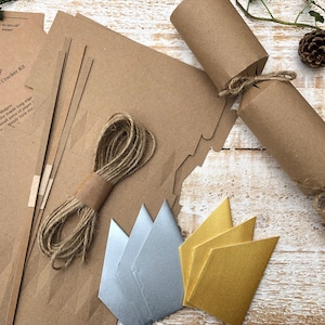May include: A kit for making rustic Christmas crackers. The kit includes brown paper tubes, twine, and instructions. There are also gold and silver paper shapes for decorating the crackers.