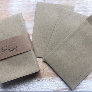 Op de afbeelding: Een stapel bruine kraftpapier enveloppen met een label met de tekst "Rustic Wrap".