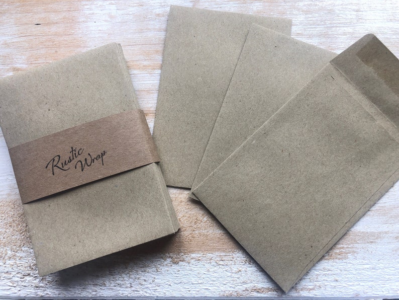 Op de afbeelding: Een stapel bruine kraftpapier enveloppen met een label met de tekst "Rustic Wrap".