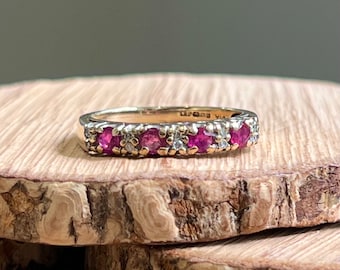 Gold ruby ring. A vintage 9K yellow gold ring, with four round cut natural rubies and double diamond spacers in a decorated setting.