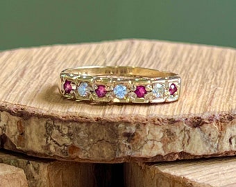 Gold ruby ring. A vintage 9K yellow gold ring, with four round cut natural rubies and diamond spacers in a decorated setting.