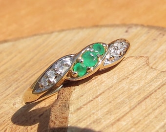 Gold emerald ring. A 9k yellow gold emerald trilogy ring with diamond accents. Petite size