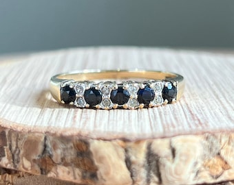 Gold sapphire ring. A 9K yellow gold midnight blue sapphire and diamond ring.